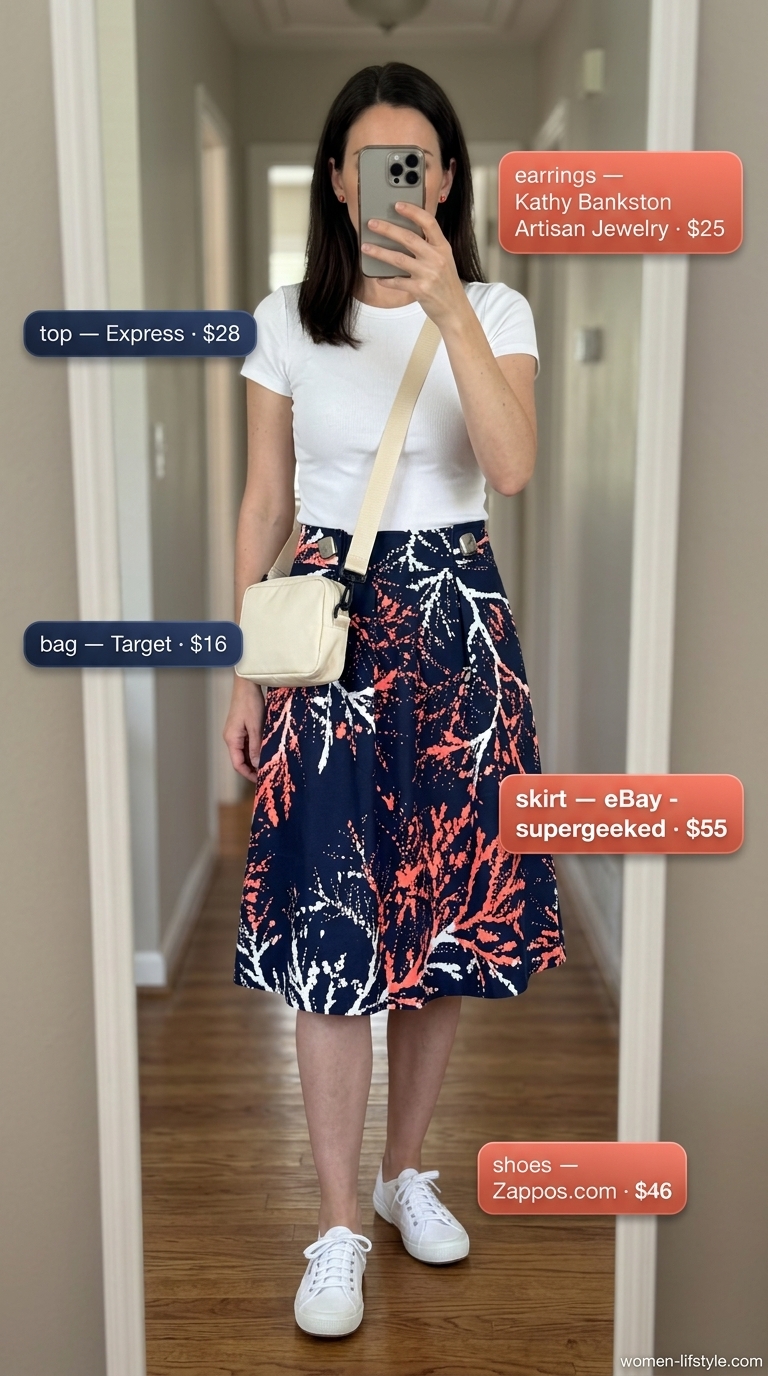 Casual tall women summer outfits 2026: Navy floral midi skirt, white tee, coral earrings, white sneakers, beige crossbody bag.