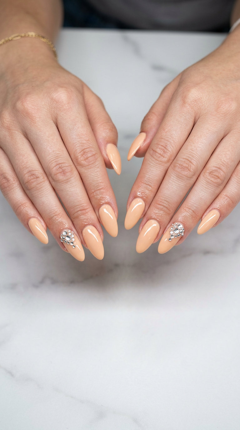 Almond summer nails 2026 for fair skin: Pale peach with clear rhinestones for a glamorous summer event.