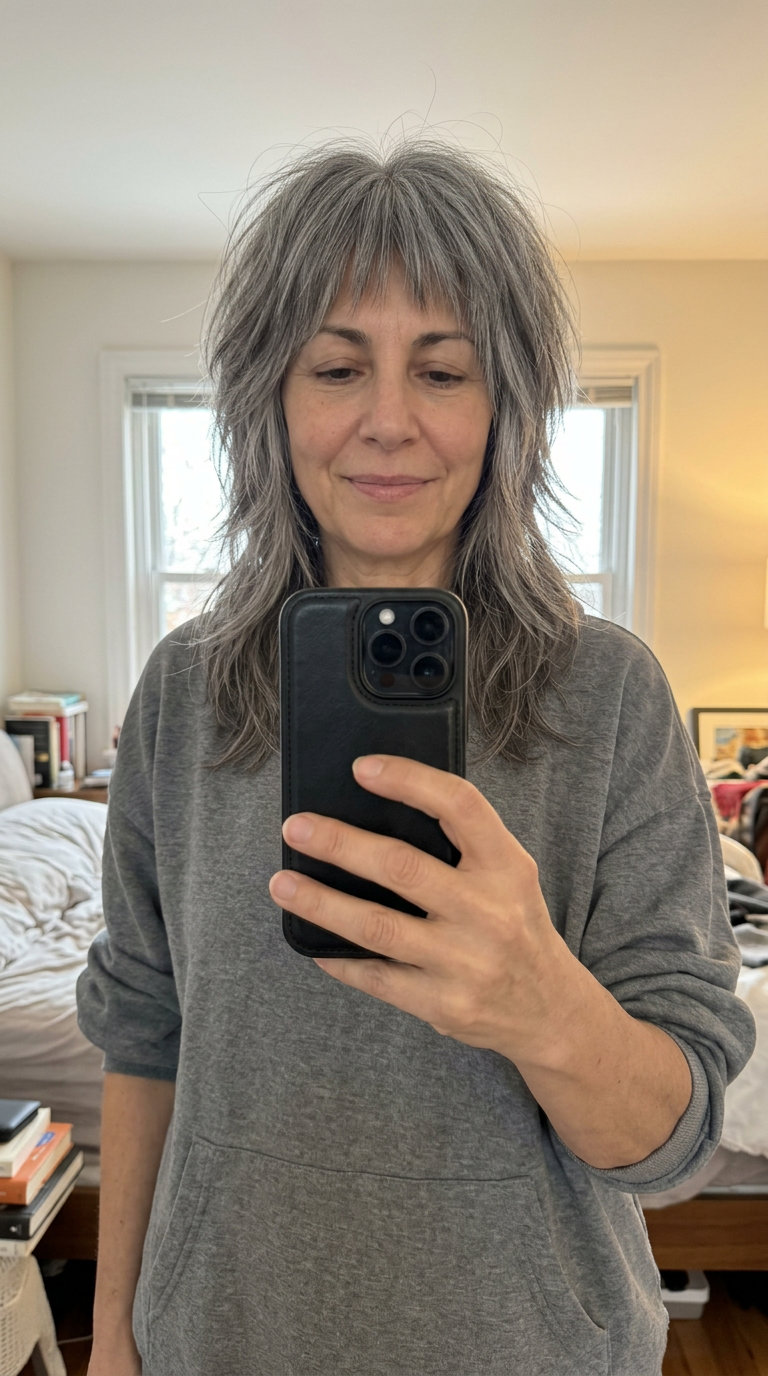 medium shag haircut with natural gray and silver streaking, choppy layers, textured fringe — edgy effortless