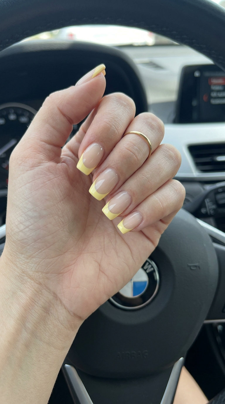 Butter Yellow French Tip Square Nails 2026 Butter yellow French tip square nails for summer 2026. Sheer nude base with opaque butter yellow tips.