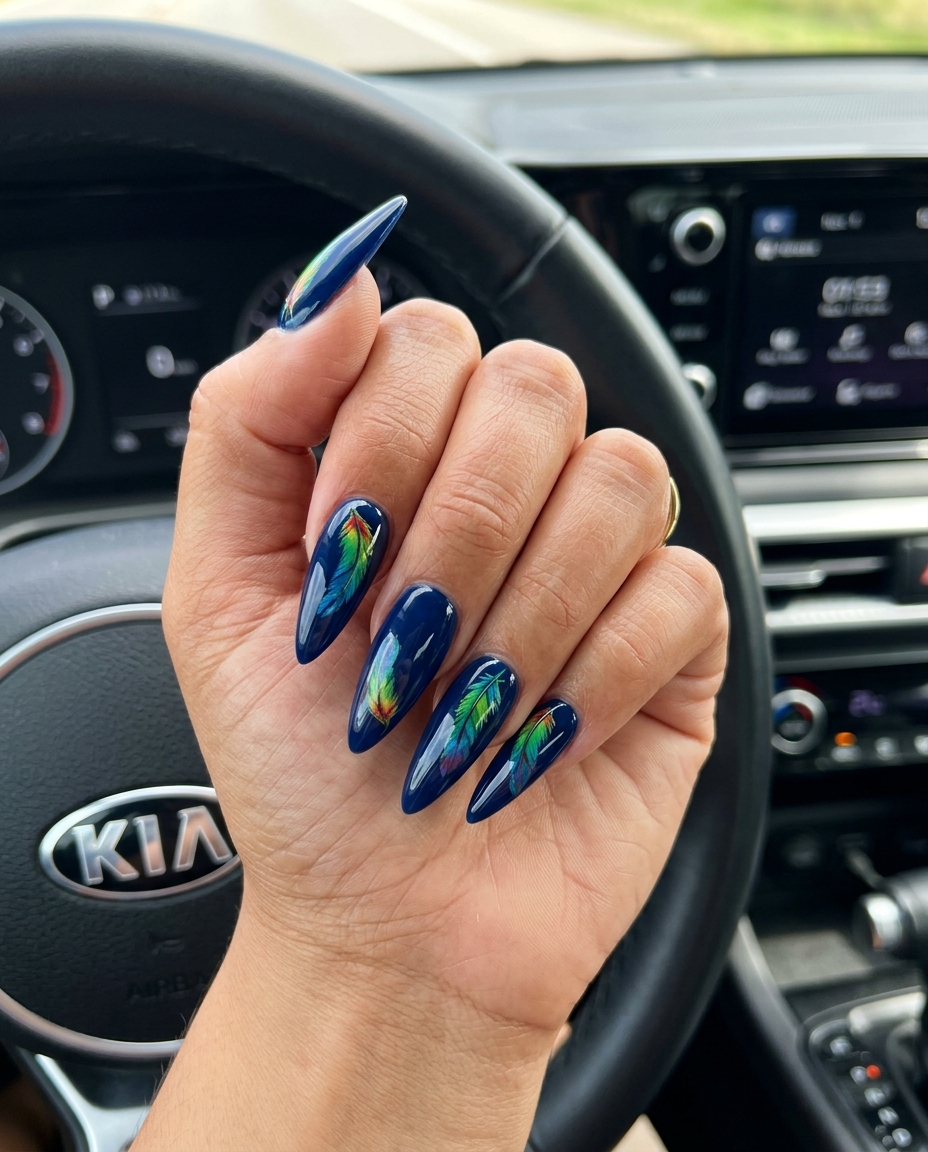 Parrot Feather Decal Stilettos 2026 Bold parrot feather decal stiletto nails in navy blue for parties. Tropical nail designs 2026.