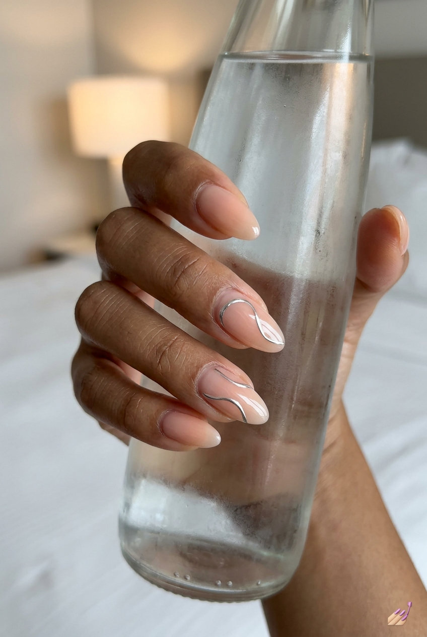 Subtle Chrome Peach: Minimalist vacation nails summer 2026 with sheer peach and silver chrome accents.