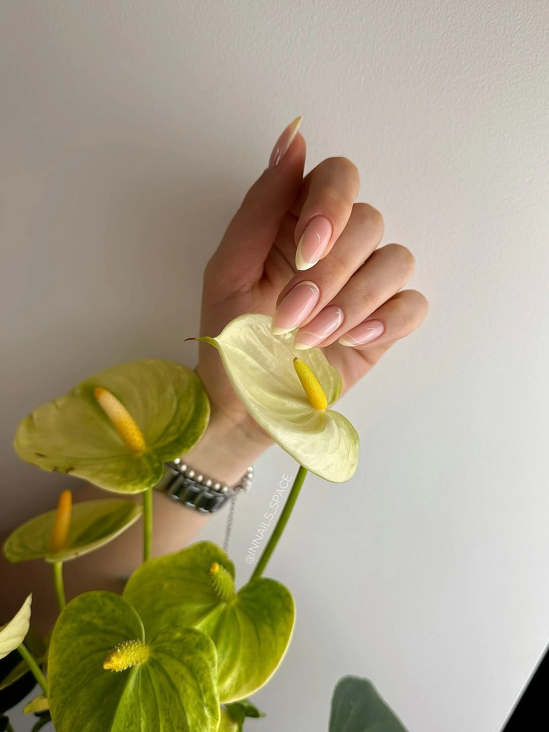 pale yellow French almond nails with glossy nude base