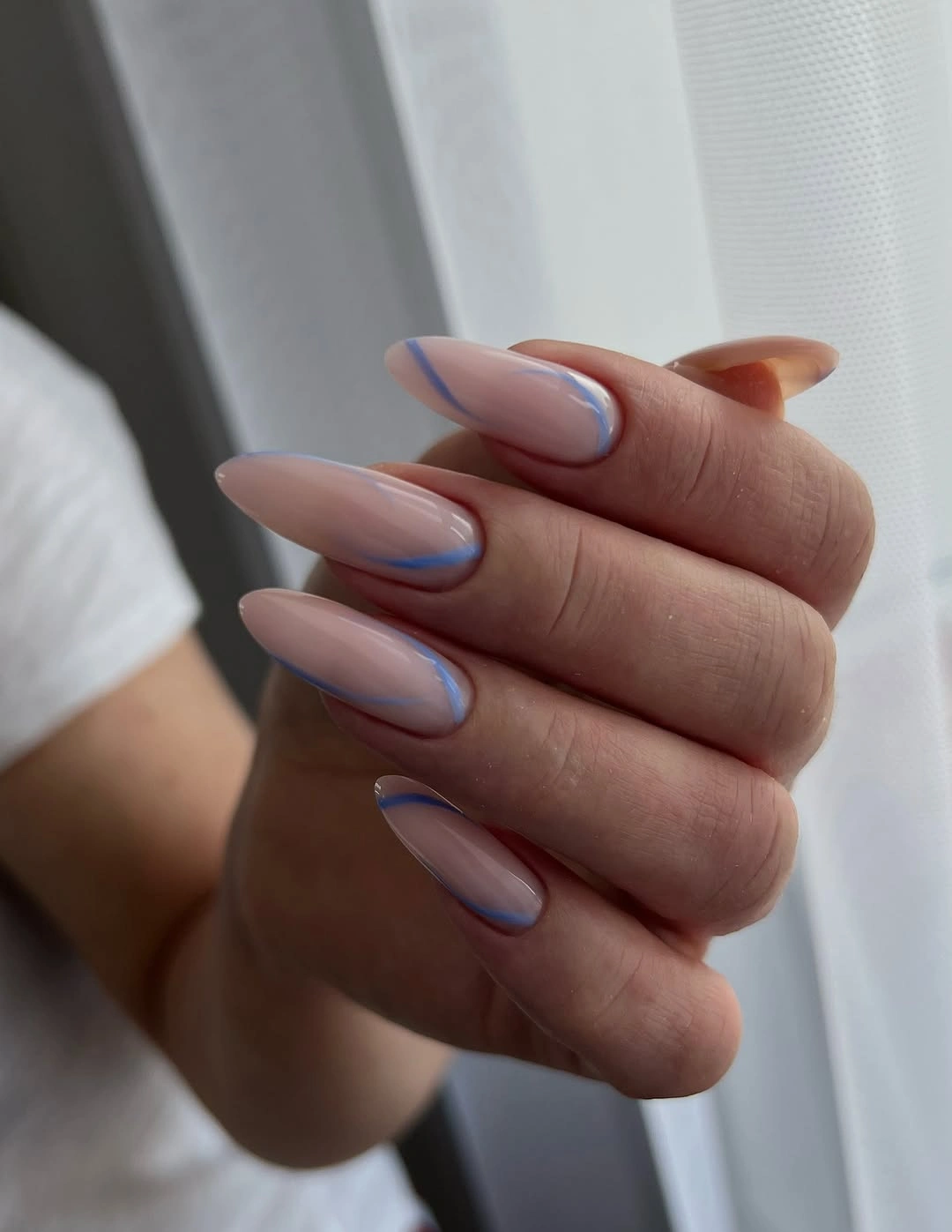 nude almond nails with blue French curves