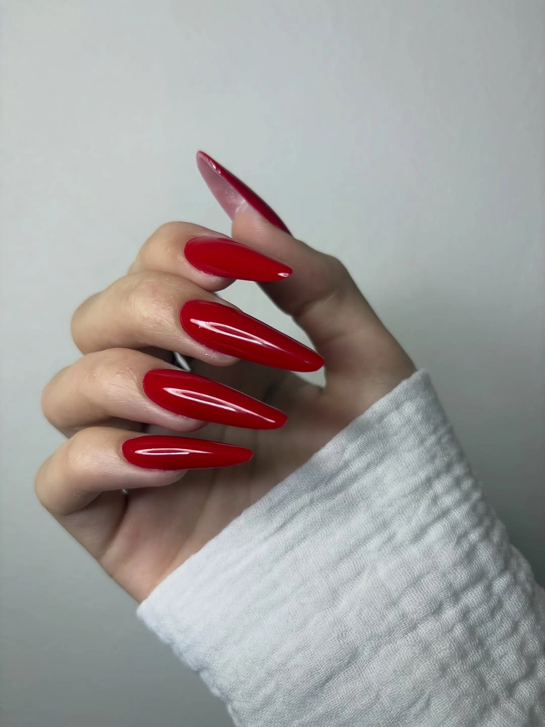 glossy red almond nails with sharp length