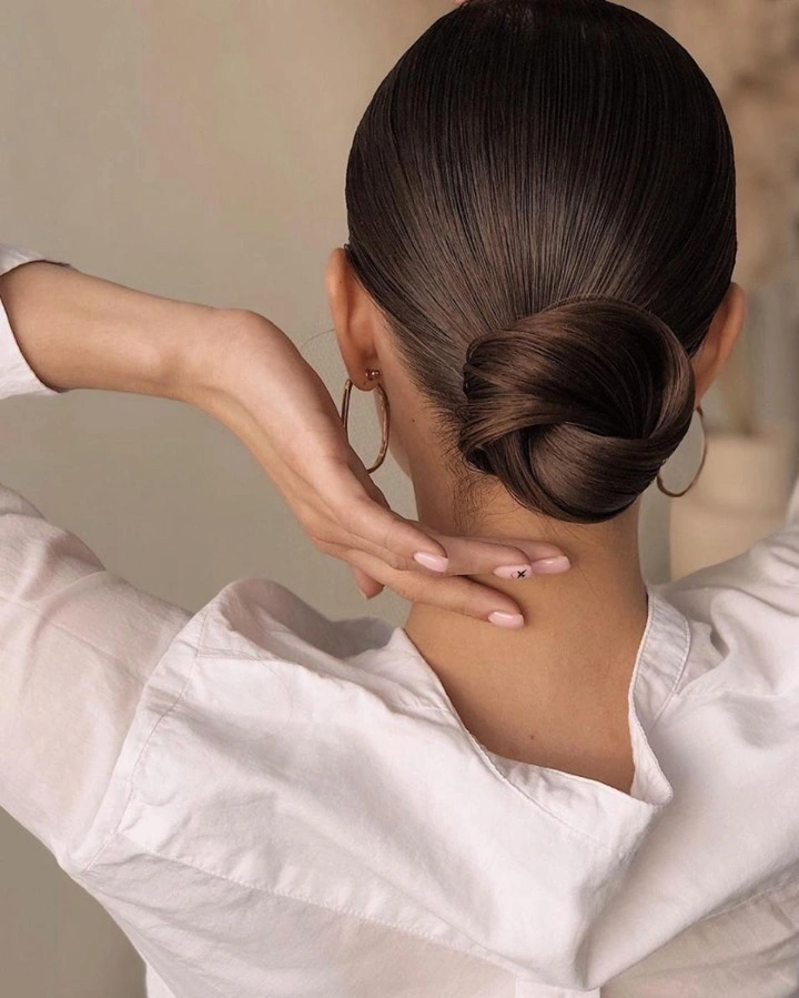 Fall hairstyles for wedding guests 2026 Classic Sleek Low Bun That Never Goes Out of Style