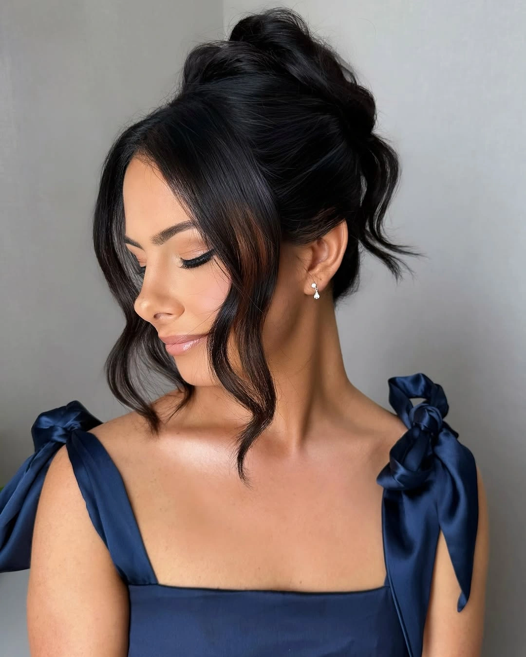 Fall hairstyles for wedding guests 2026 Classic Soft Bun with Face-Framing Curtain Pieces