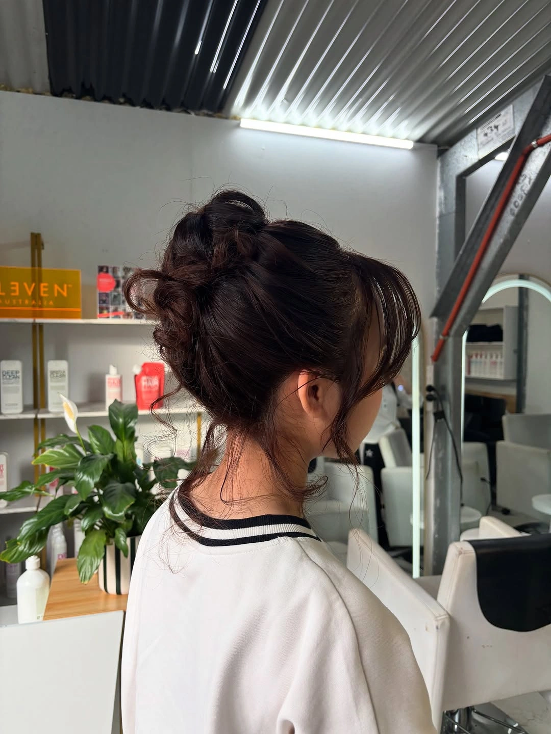 Fall hairstyles for wedding guests 2026 Soft Textured Updo with Curtain Bangs and Loose Tendrils