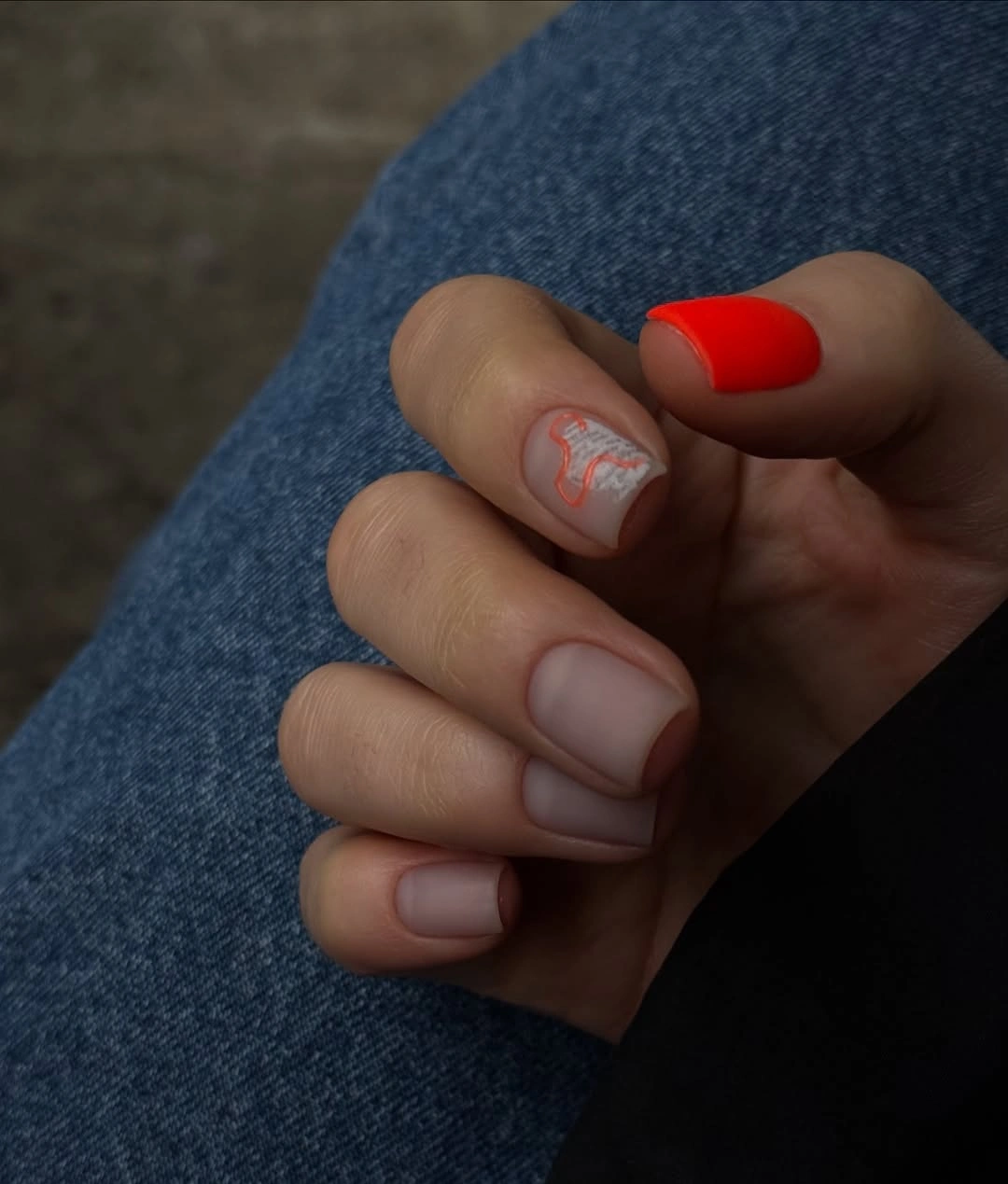 Fall manicure 2026 Red Accent Manicure With Nude Swirl Detail
