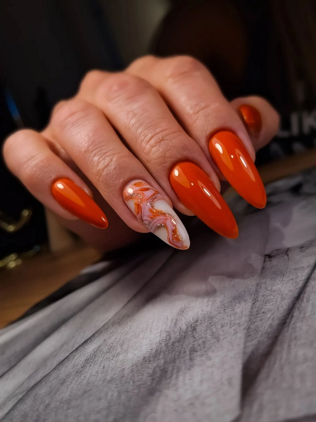 Fall manicure 2026 Orange Almond Nails With a Floral Accent