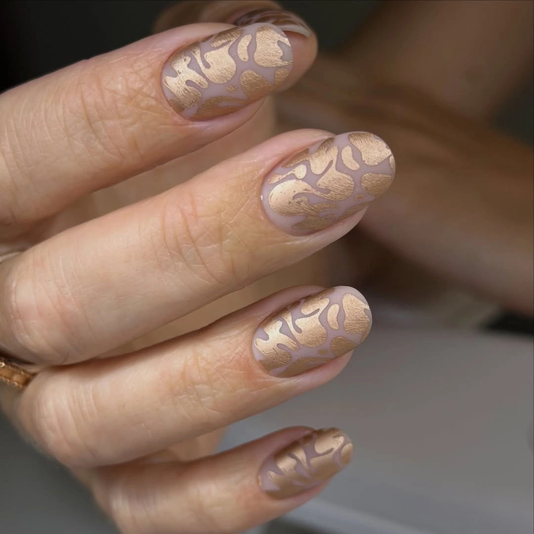 mauve medium rounded nails with brushed gold abstract pattern