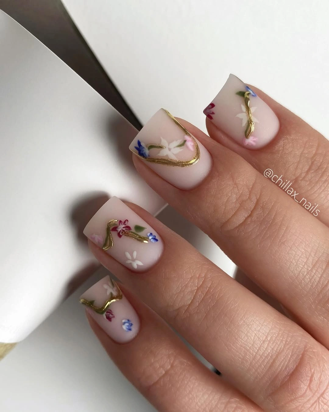sheer square nails with small flowers and gold curved lines