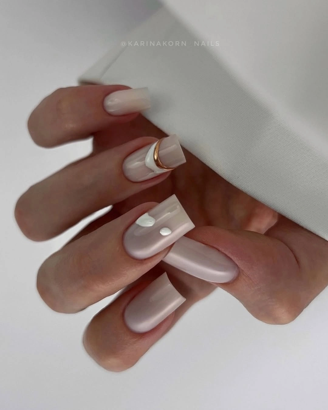 pearl neutral square nails with white dots and gold ring accent