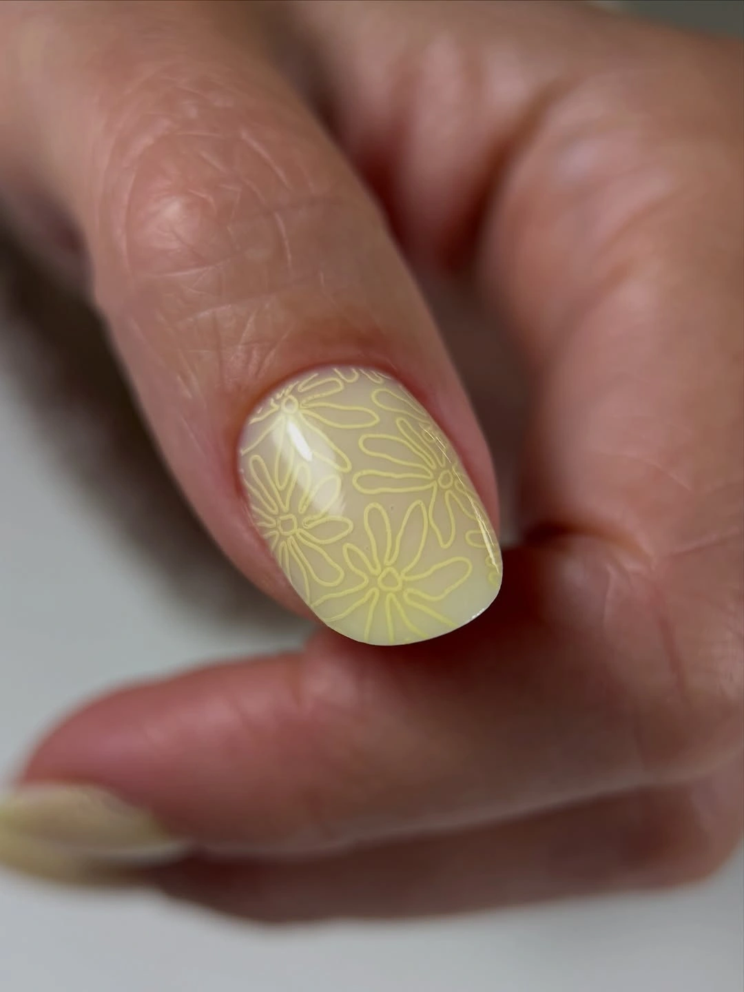 soft yellow rounded nail with delicate floral line art