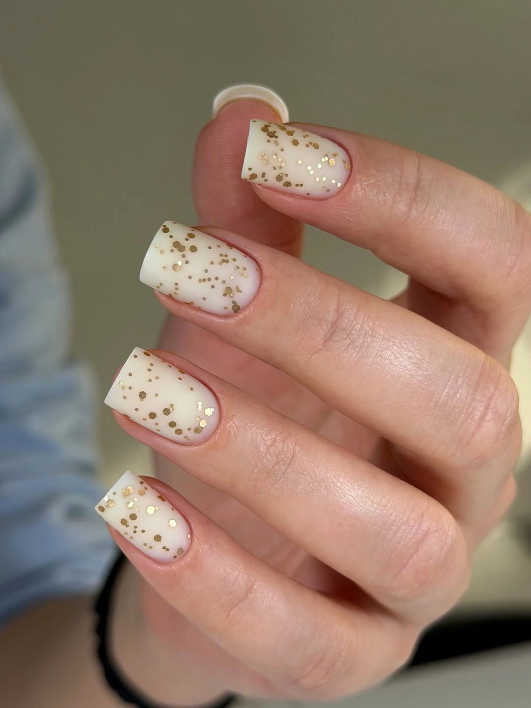milky square nails scattered with gold glitter flecks