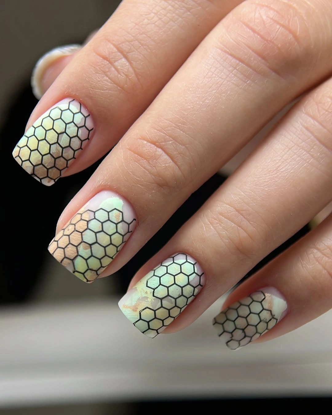 square pastel nails with black honeycomb grid pattern