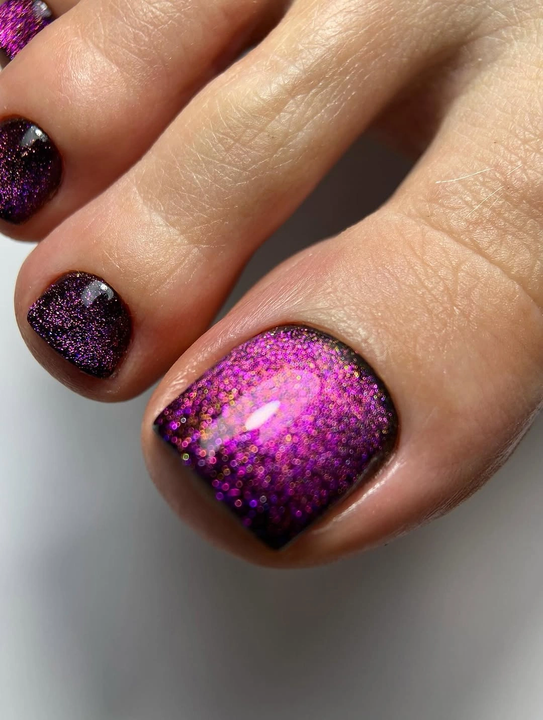 purple glitter pedicure with dark glossy base