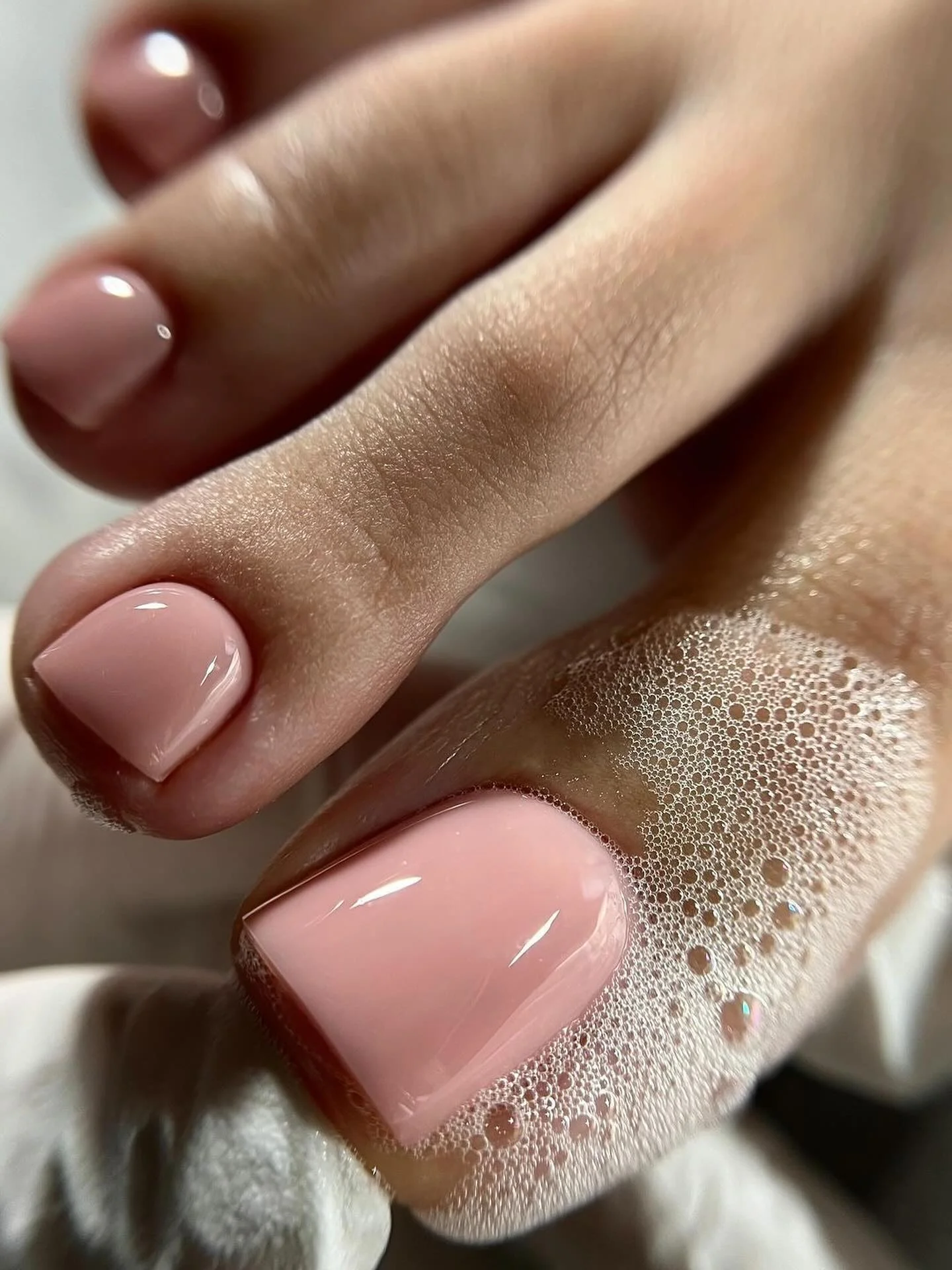 soft blush pink glossy pedicure on rounded toenails