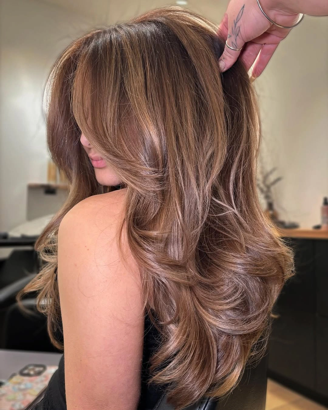 Hair Lowlights: Color Ideas and Inspiration Soft Cinnamon Mocha Lowlights with Voluminous Butterfly Layers