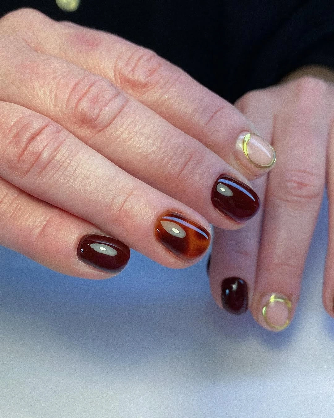 September nails color 2026 Burgundy Orange And Nude Short Nails With Gold Detail