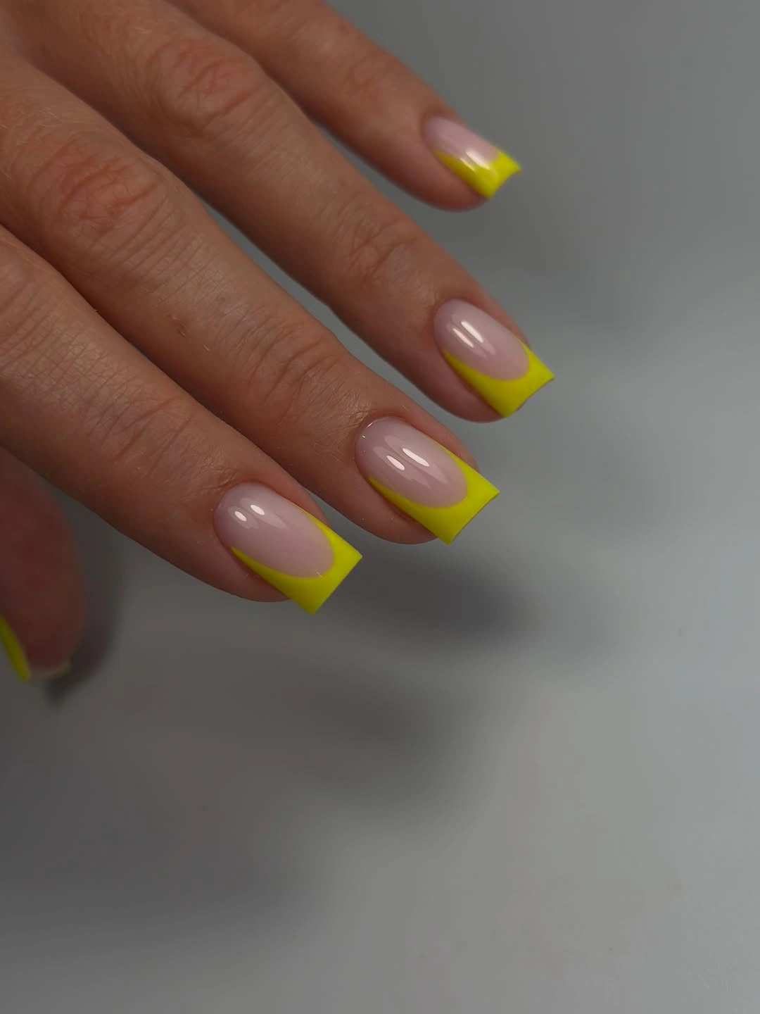 pink rounded nails with neon yellow French tips