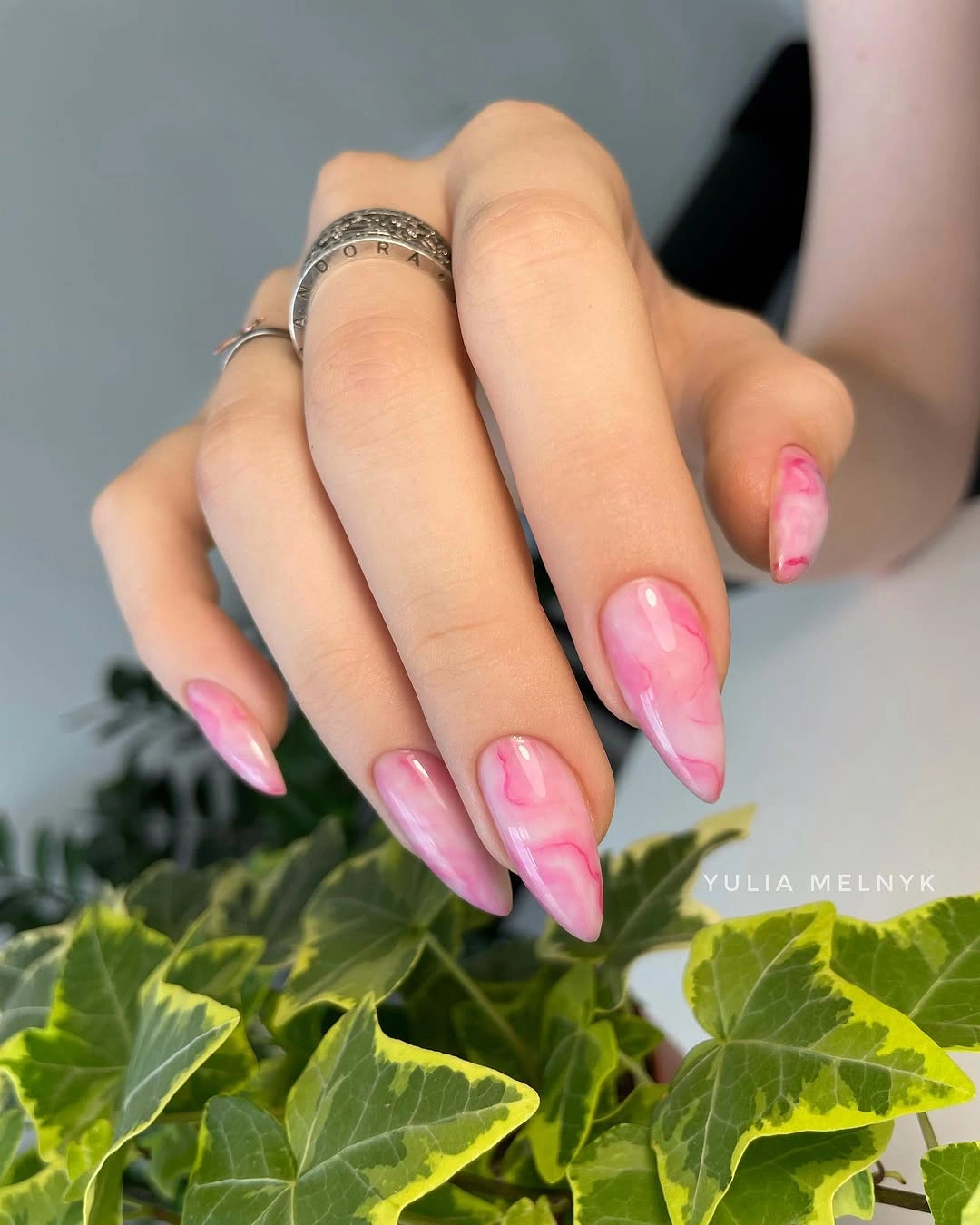glossy pink almond nails with soft marbled swirls