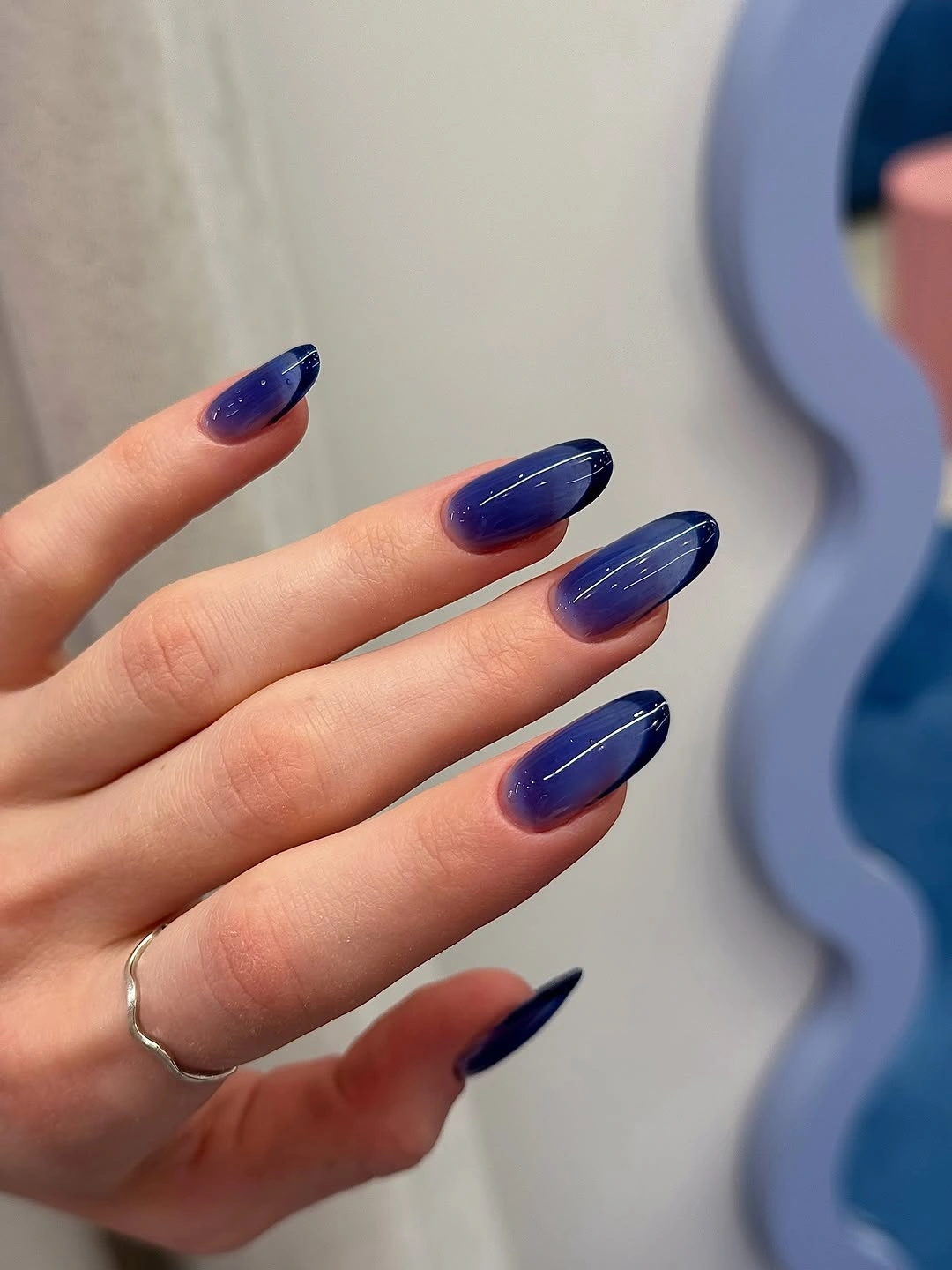 deep navy metallic almond nails with glossy reflection