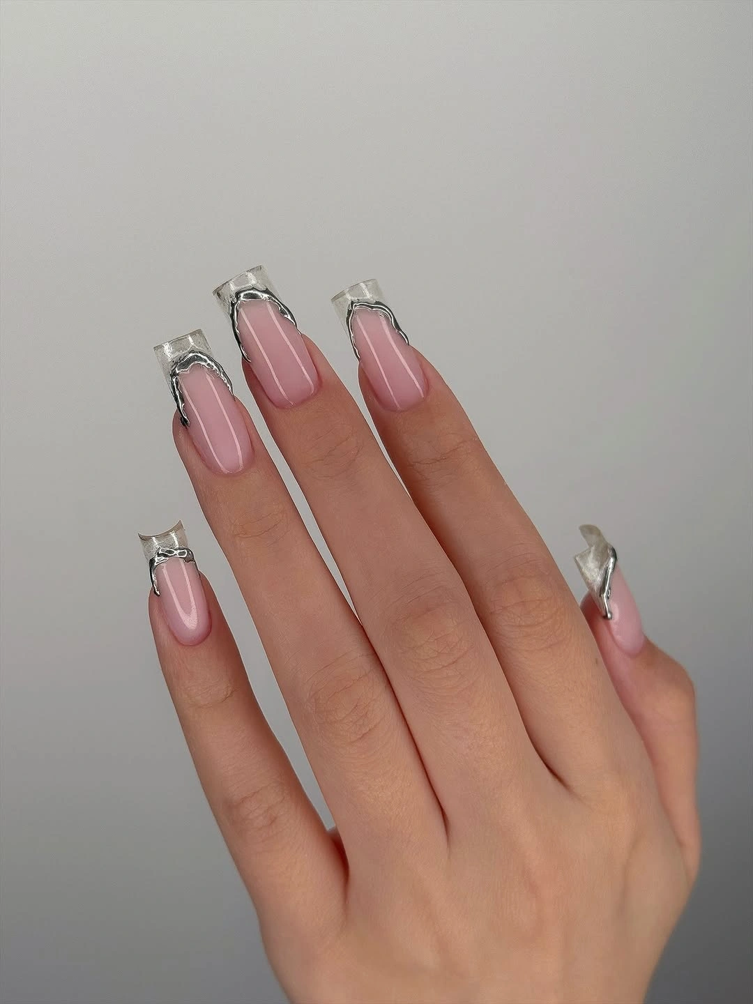 long pale pink nails with clear metallic geometric tips