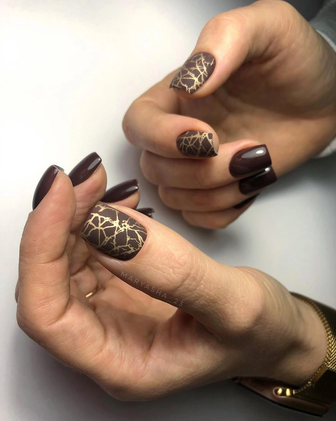 Brown almond nails with delicate pale linework on nude accents