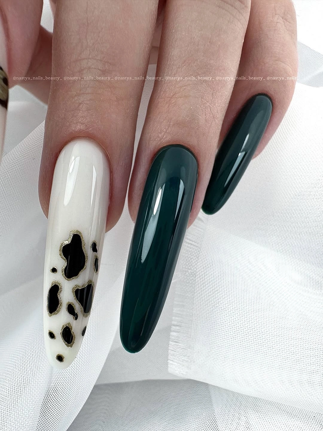 Long deep green nails with one pale spotted accent