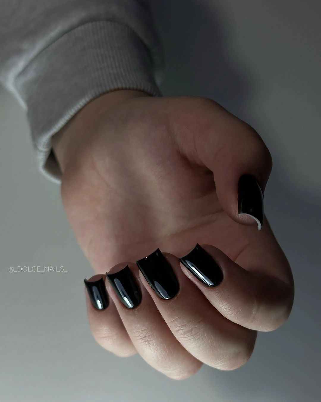 Long pointed black nails in dramatic side lighting