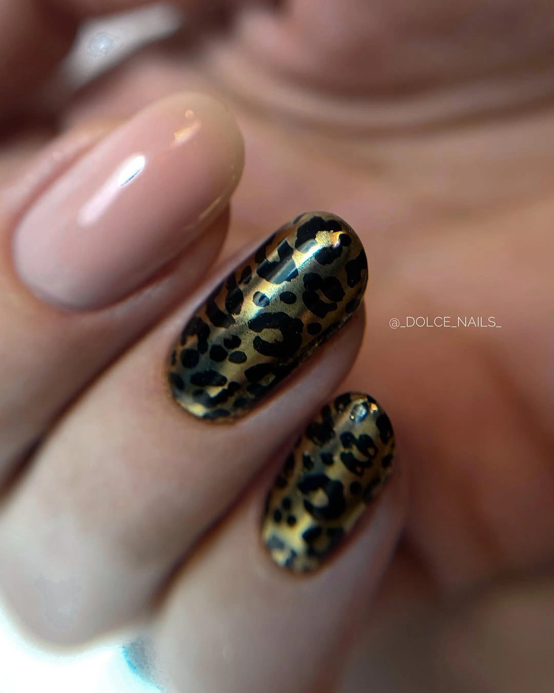 Nude almond nails with concentrated dark spotted accents