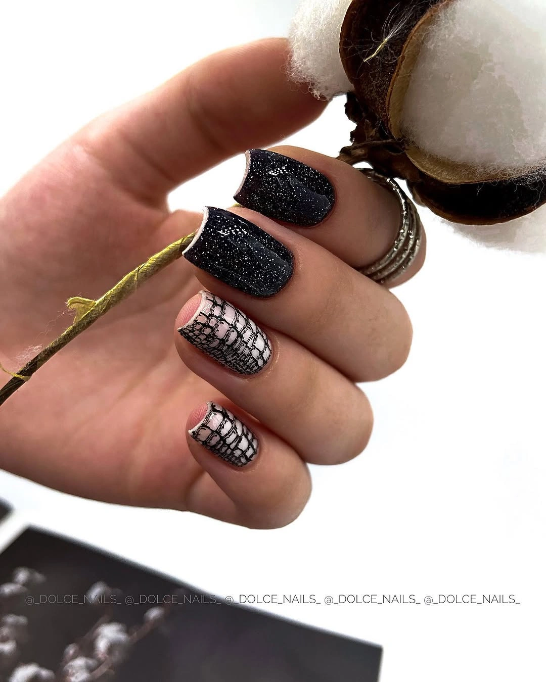Short black textured nails with pale mesh-like accents