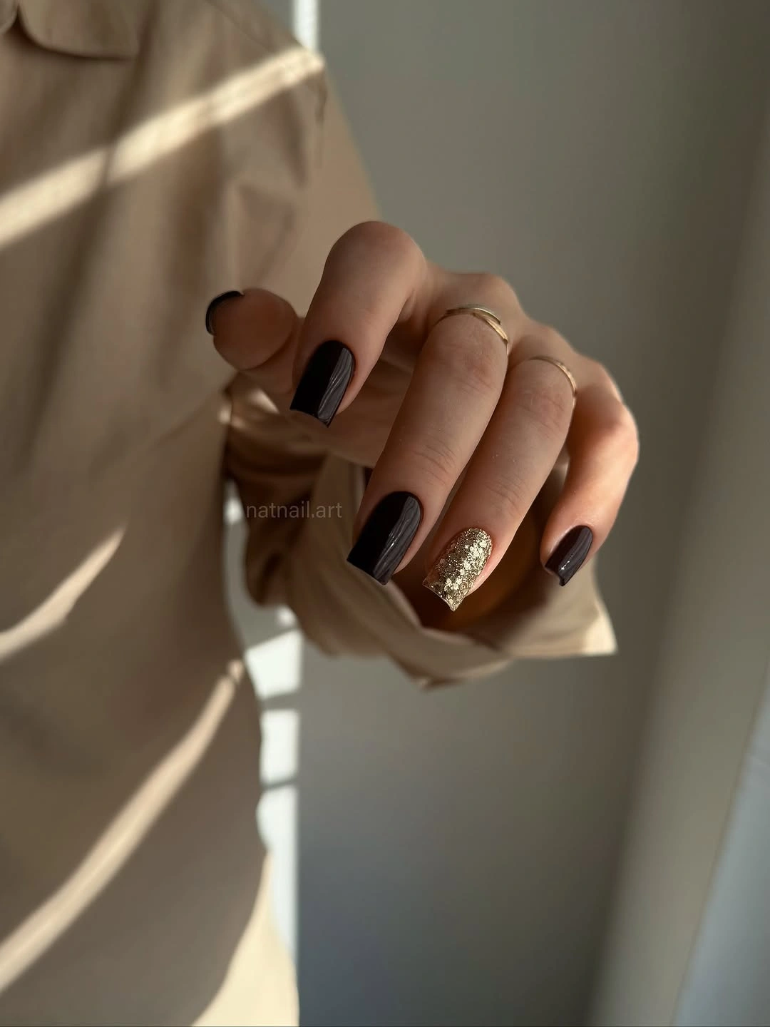 Short black nails with one dense metallic accent nail