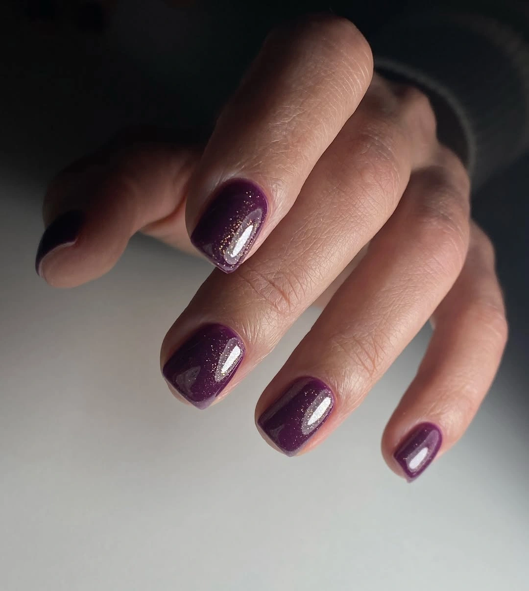 Short plum nails with dense fine reflective sparkle