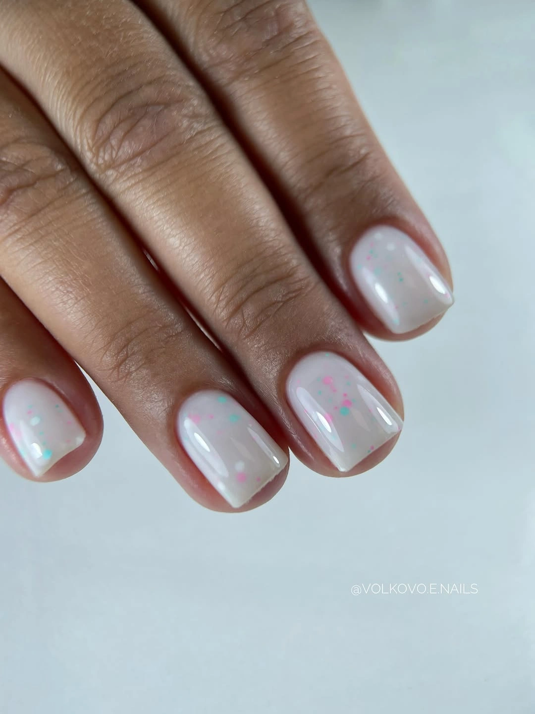 Short milky white nails with tiny pastel confetti flecks