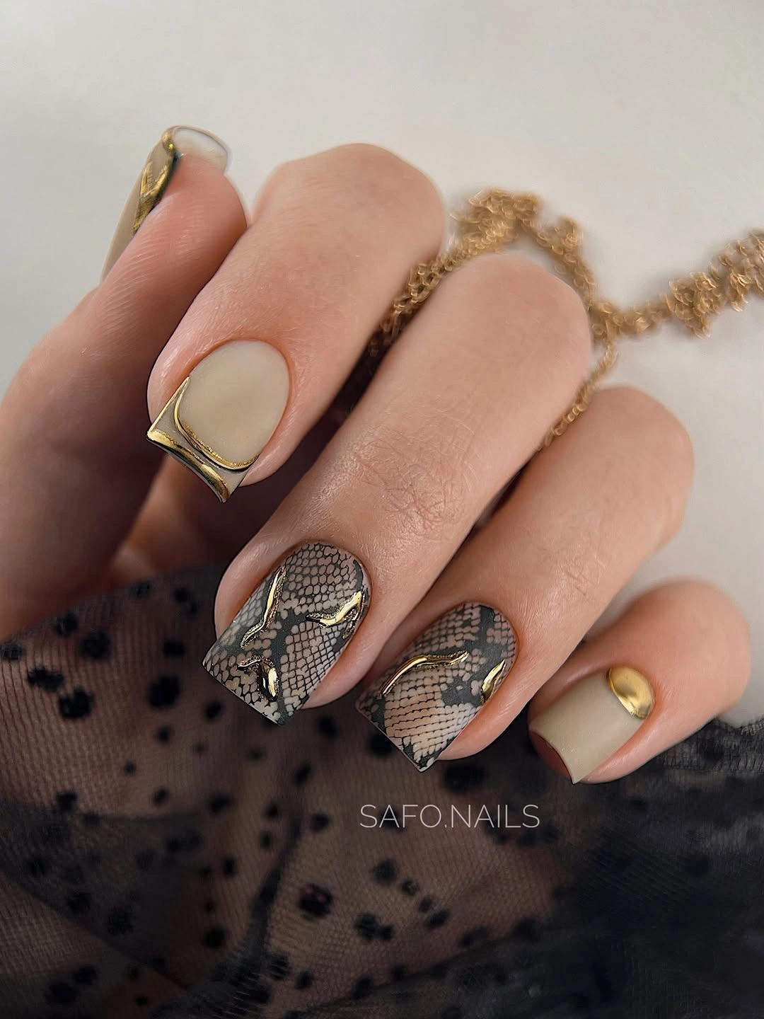 Short neutral square nails with gold and spotted accents