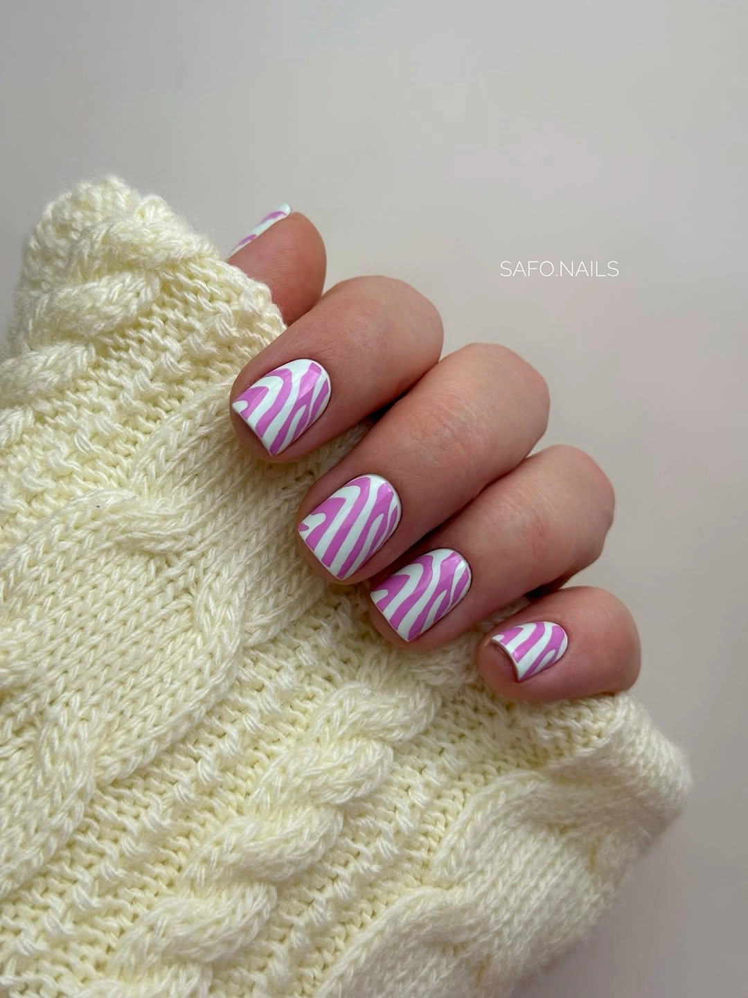 Short lavender nails with white and pink wavy stripes