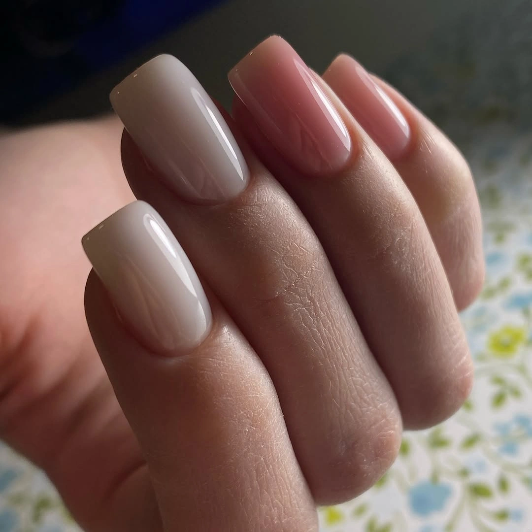 Glossy electric blue square nails against bright pink clothing
