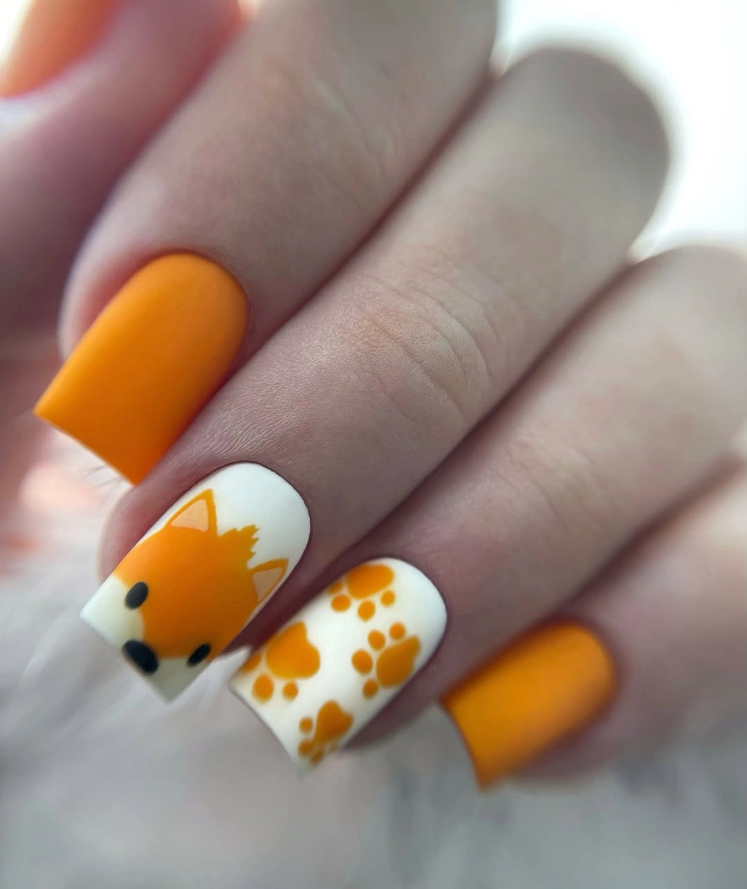 Orange square nails with white illustrated accent fingers