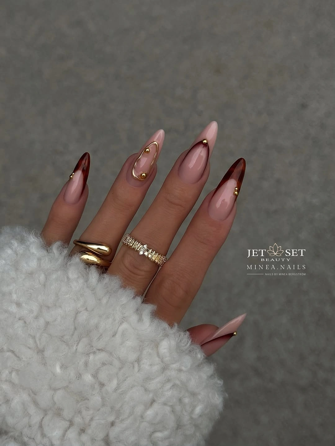 Blush almond nails with burgundy tips and gold details
