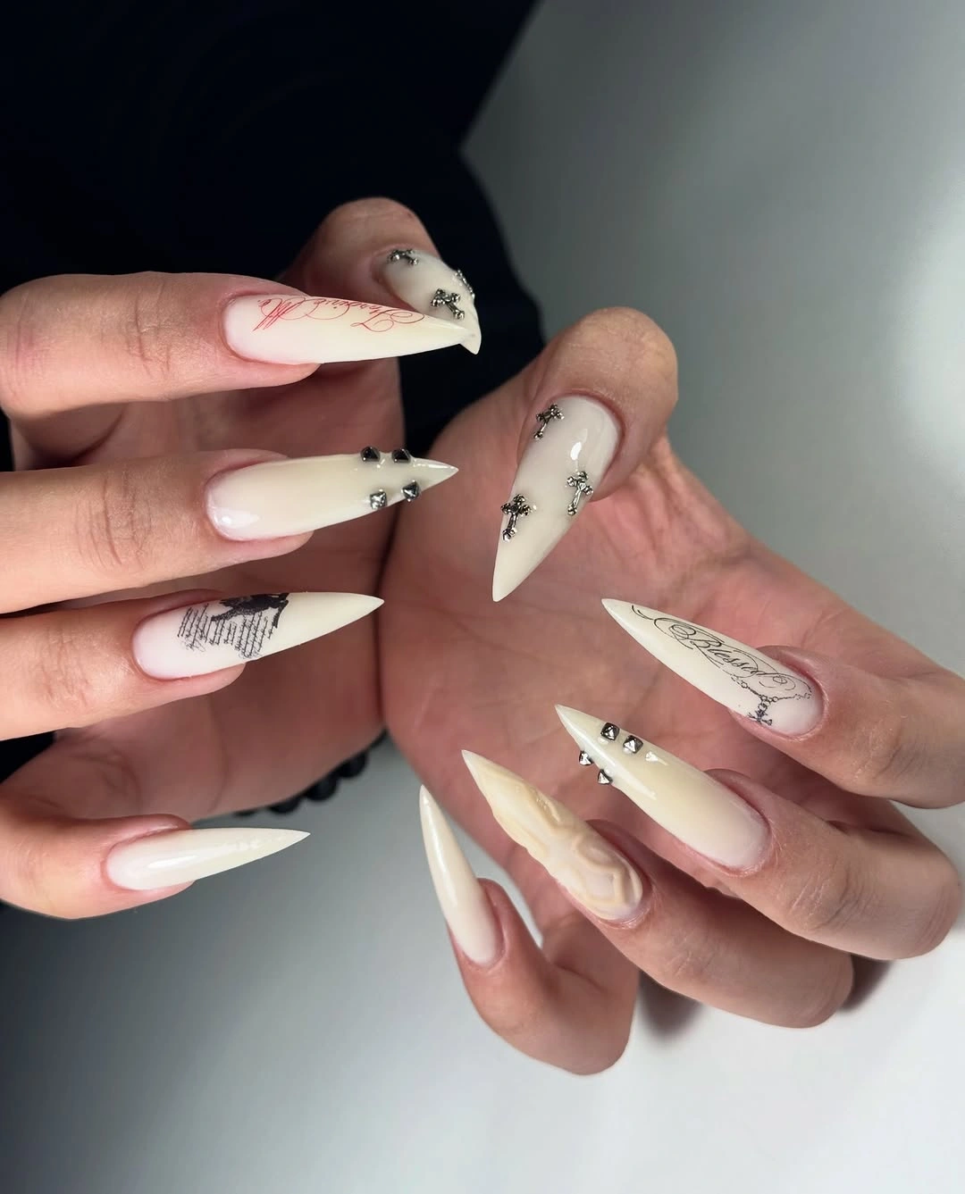 Ivory pointed nails with fine black lines and tiny studs