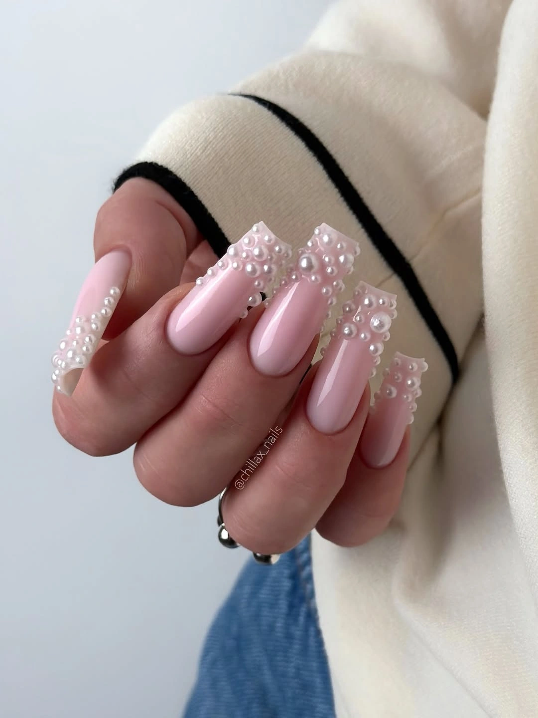 Long pink almond nails with white bead-like borders