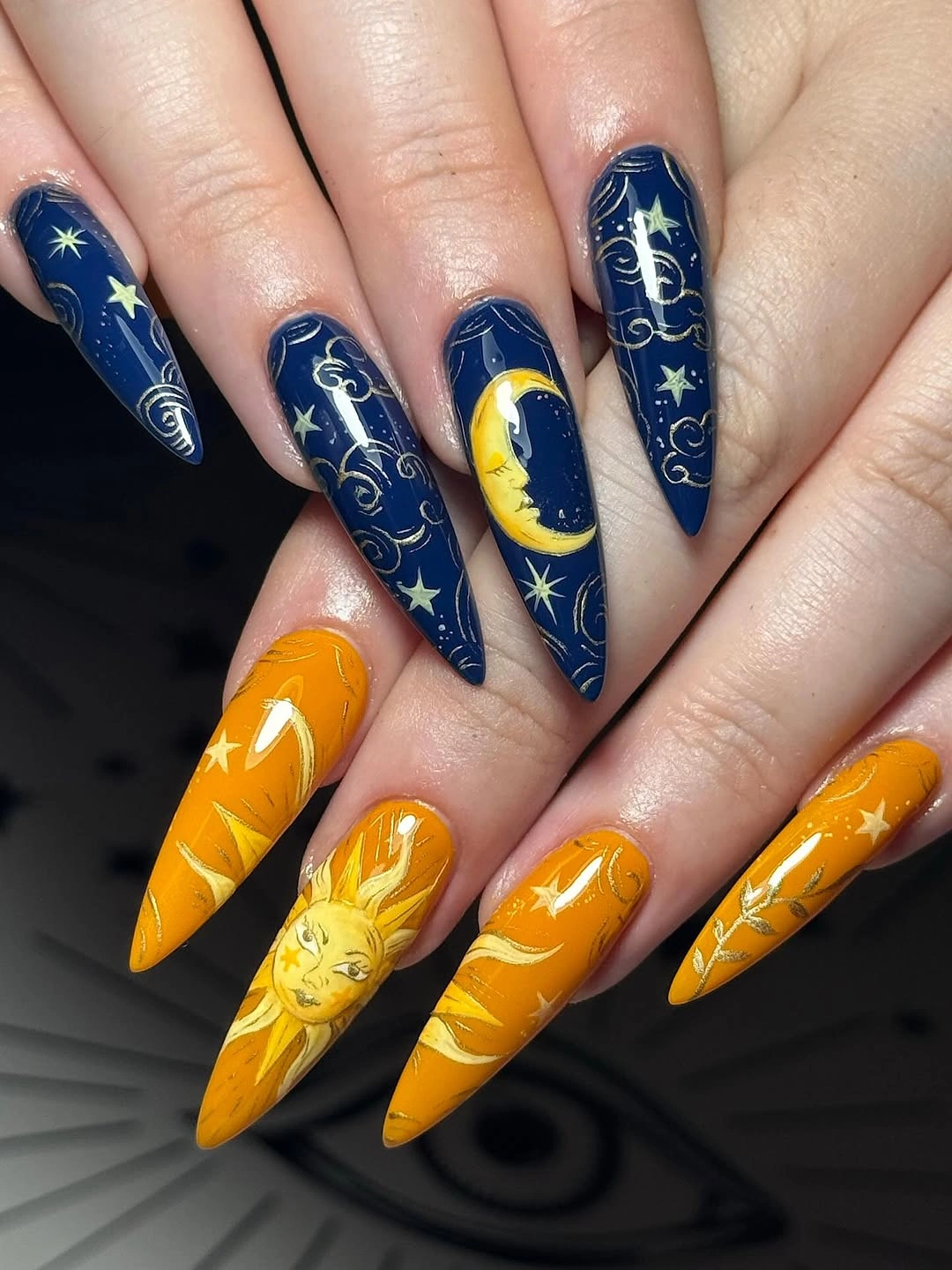Stiletto navy and orange nails with moons and stars
