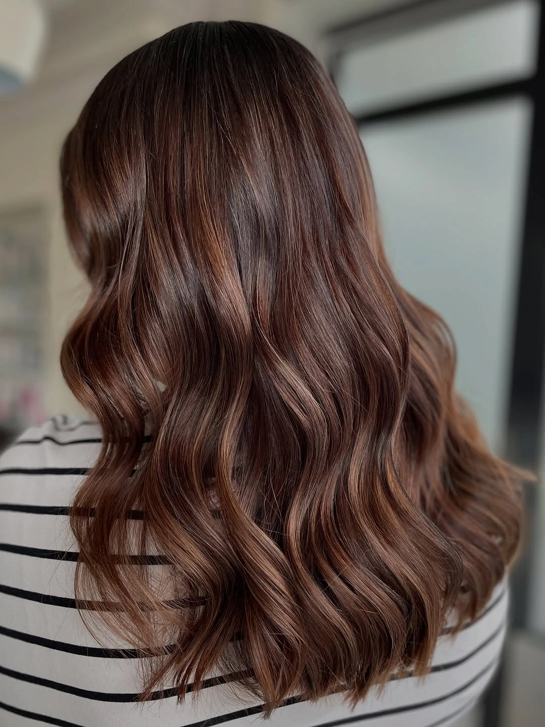 Rich chestnut brown hair in broad glossy waves