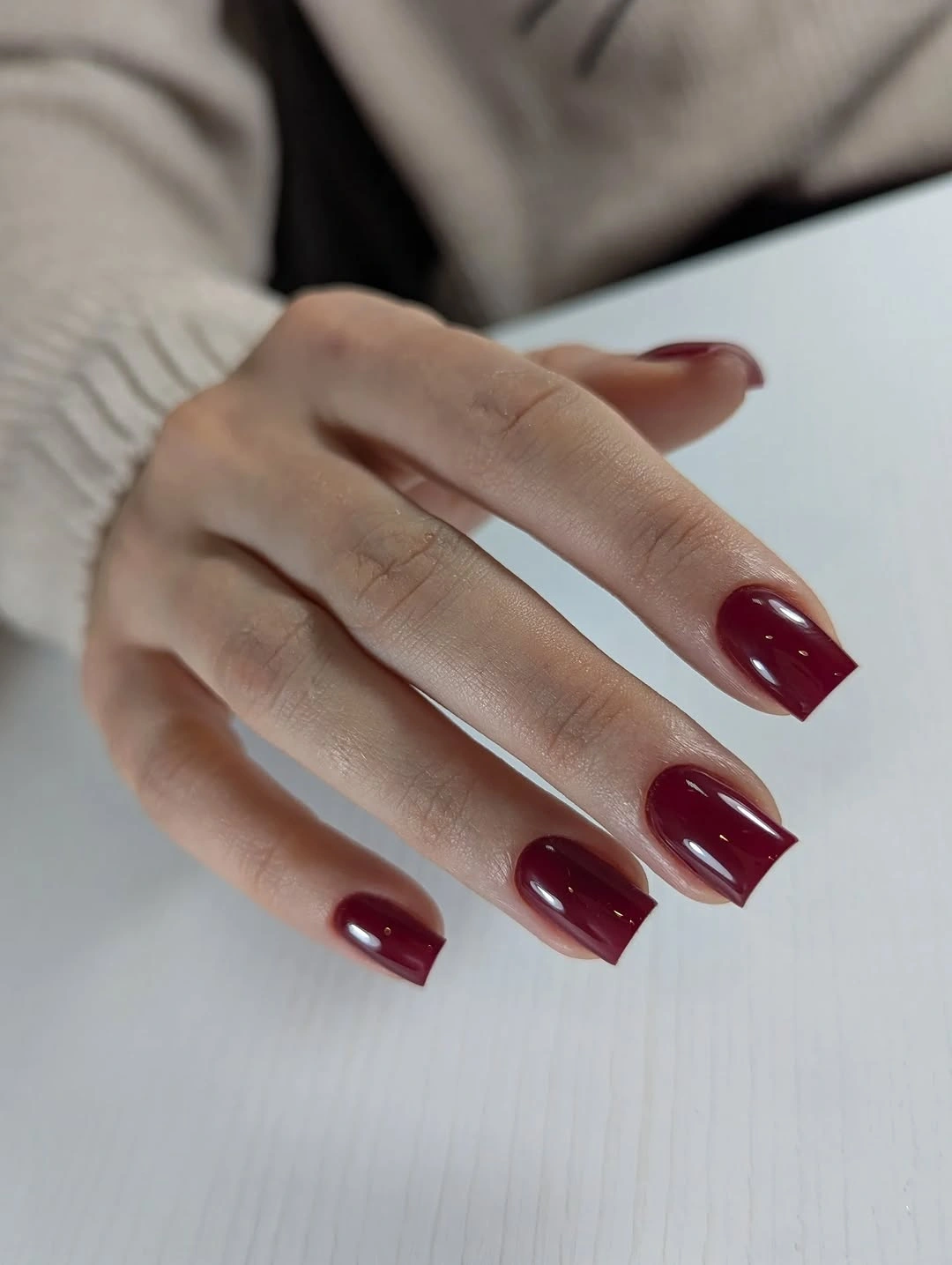 Short glossy burgundy square nails with a clean everyday silhouette