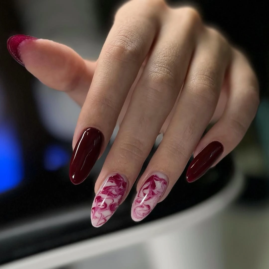 Long burgundy nails with two pale pink red marble accents