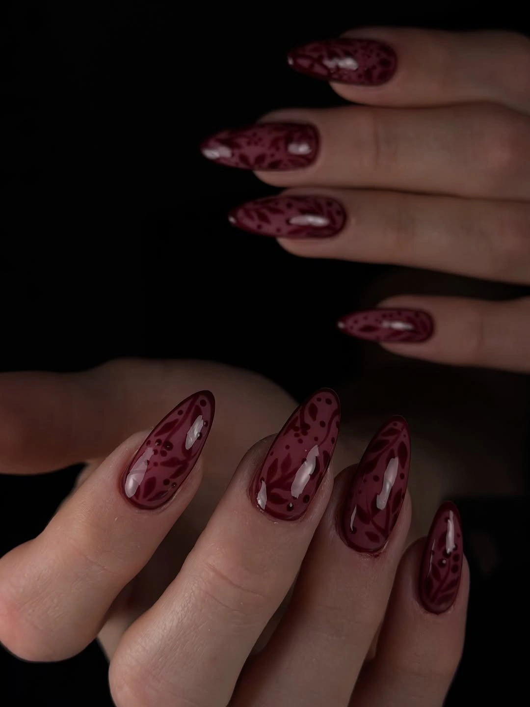 Burgundy almond nails with layered red translucent marbling
