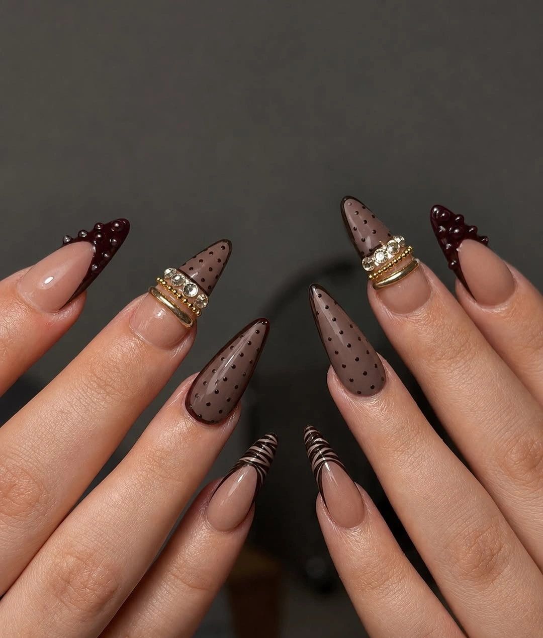 Taupe almond nails with dark speckles and wine accents