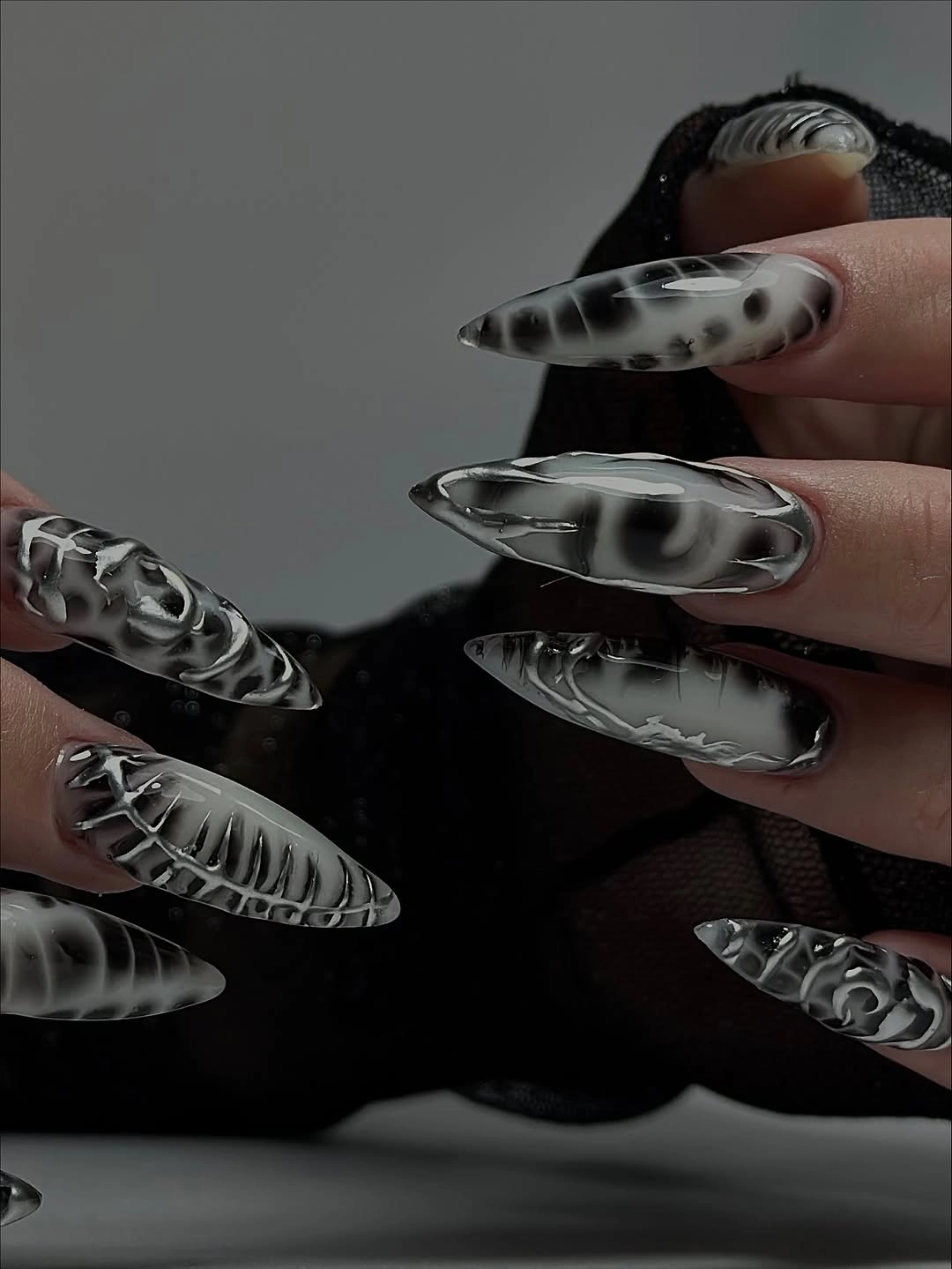 Very long pointed nails with silver abstract lines